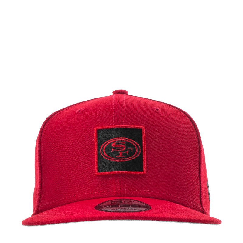 Red baseball cap with black square SF logo patch and curved brim