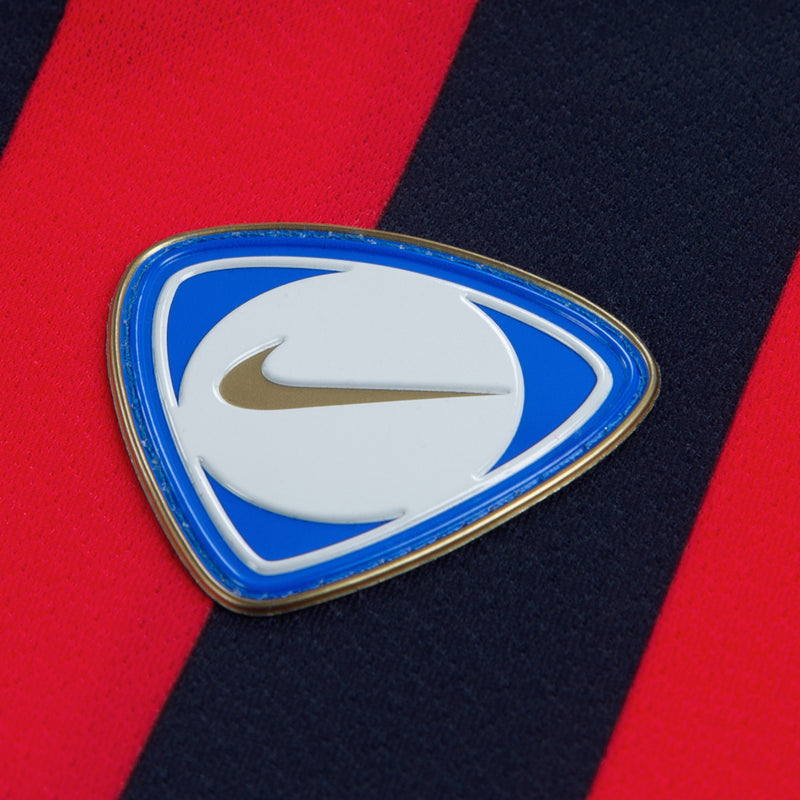 Embroidered team crest patch with Nike swoosh on red-and-dark-blue jersey
