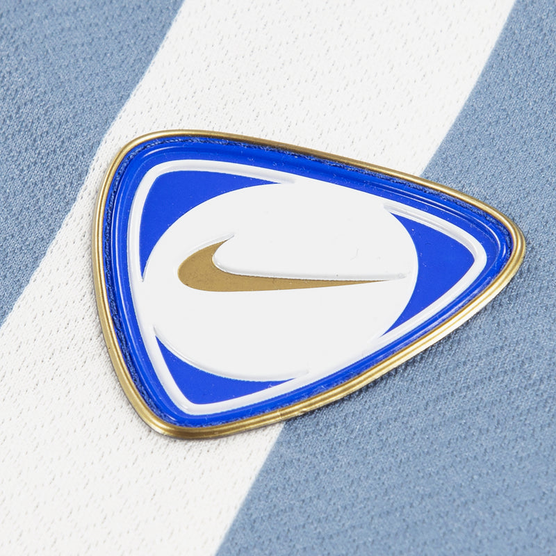Blue and white oval Nike logo patch with gold border on jersey