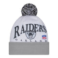 White and gray knit beanie with dark pom and Raiders graphic on front