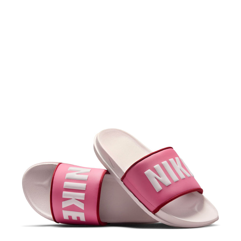 Women's slide sandals shown side by side, pink straps with NIKE lettering