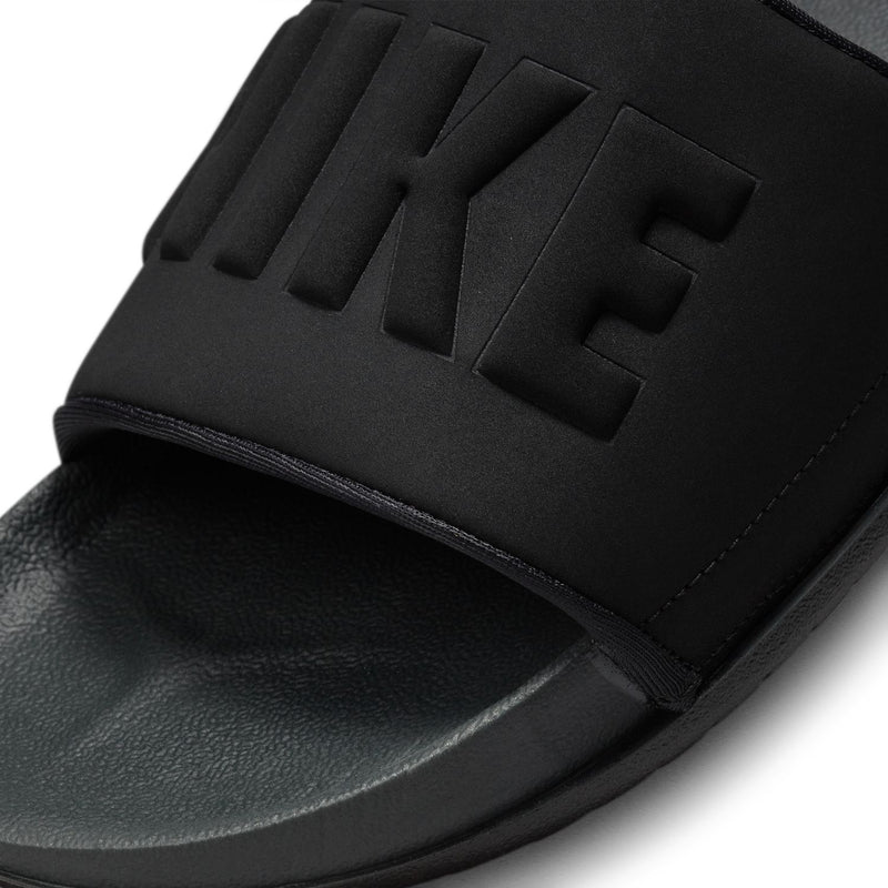 Women's black slide sandal close-up with embossed NIKE lettering on strap
