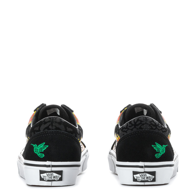 Black sneakers with green flying-V logo, marigold heel artwork, and white sole