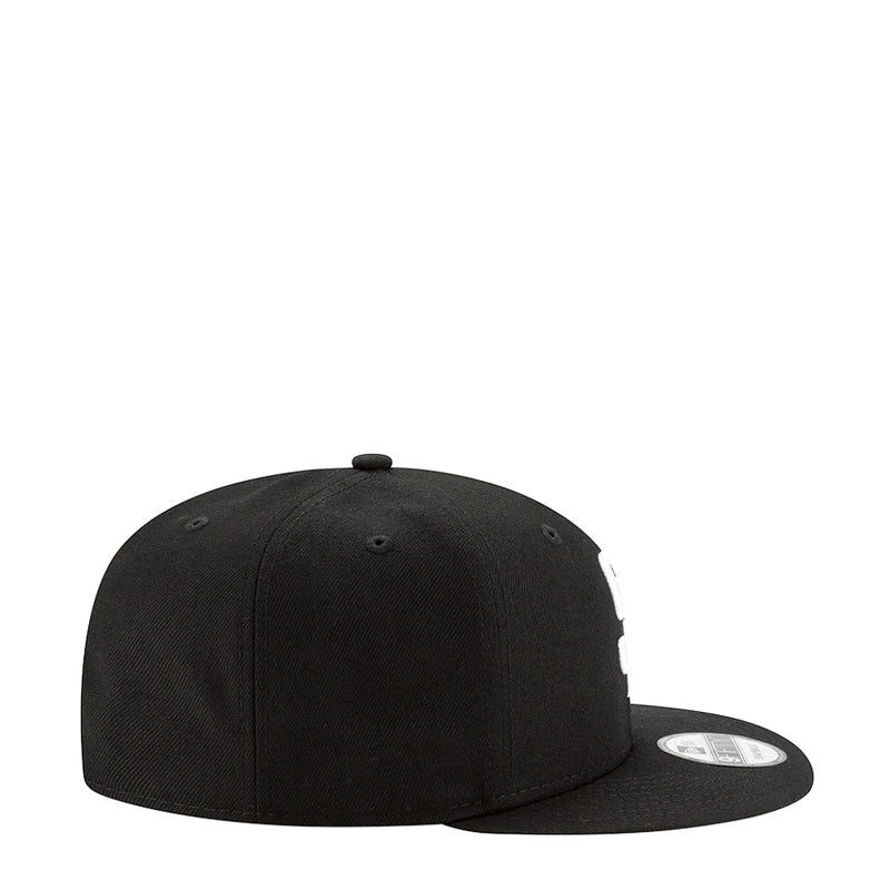 Black baseball cap, side view with curved brim and stitch panels