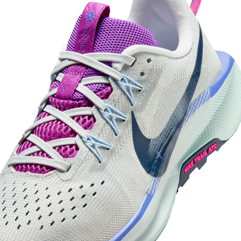 Women's trail shoe upper close-up, light gray knit with purple overlays and blue laces