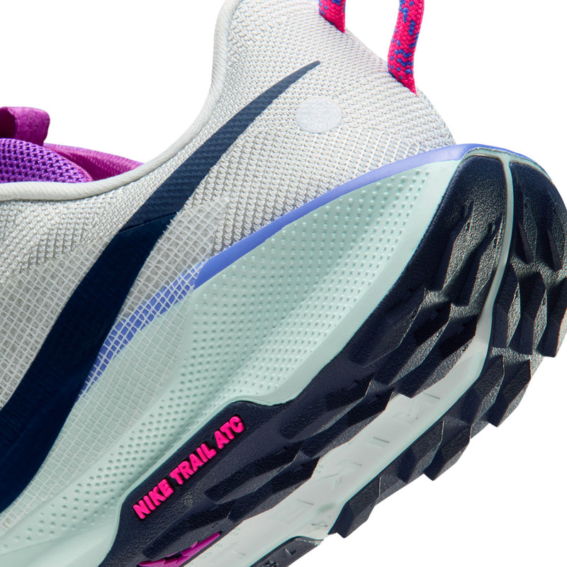 Women's trail shoe close-up, light gray midsole with 'NIKE TRAIL ATC' marking