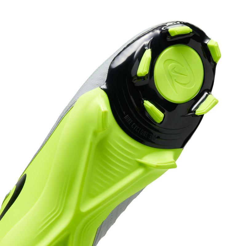 Men's FG soccer cleat sole close-up with black heel plate and volt green studs.
