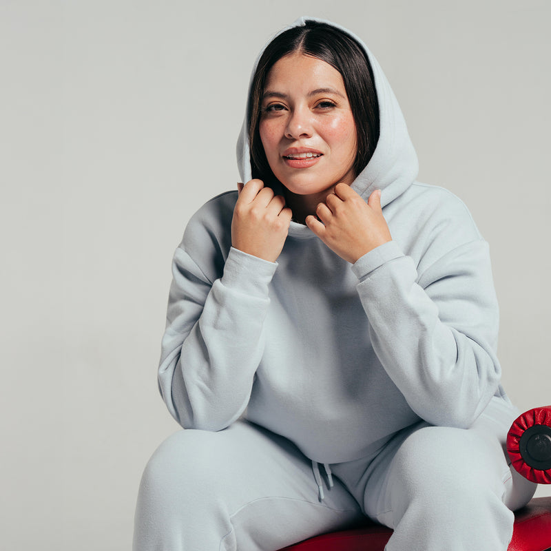 Light blue-gray women’s fleece hoodie with hood up and drawcord