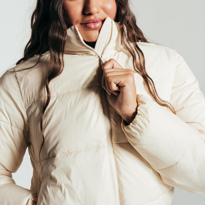 Women's parchment puffer jacket close-up: full-zip and stand collar