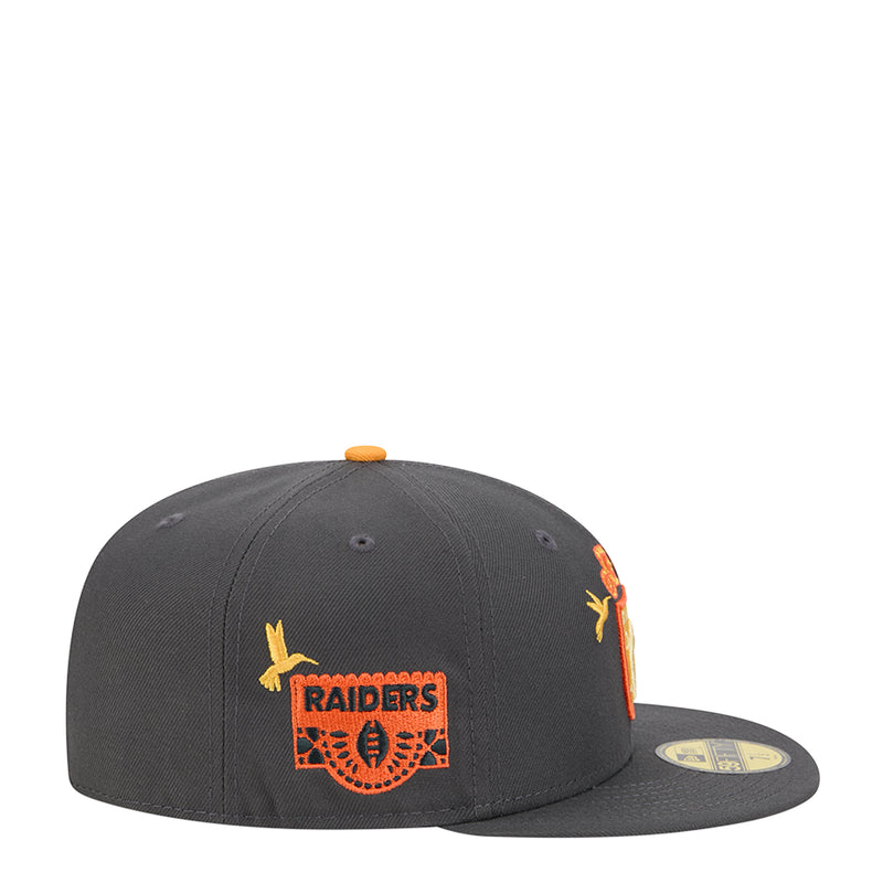 Dark grey baseball cap with orange top button, Raiders logo patch and yellow bird details