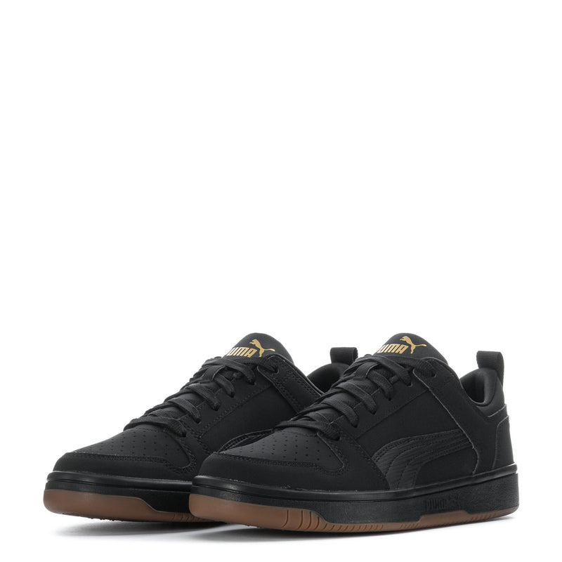 Pair of black youth low-top sneakers with lace-up and gum-brown outsole