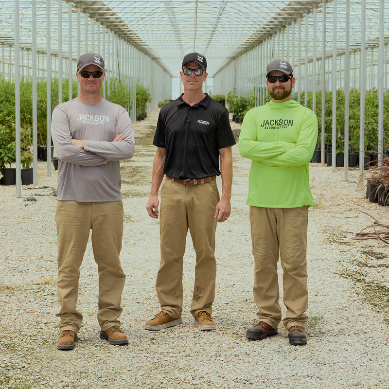 Dark khaki work pants worn by three men, relaxed straight dungaree fit