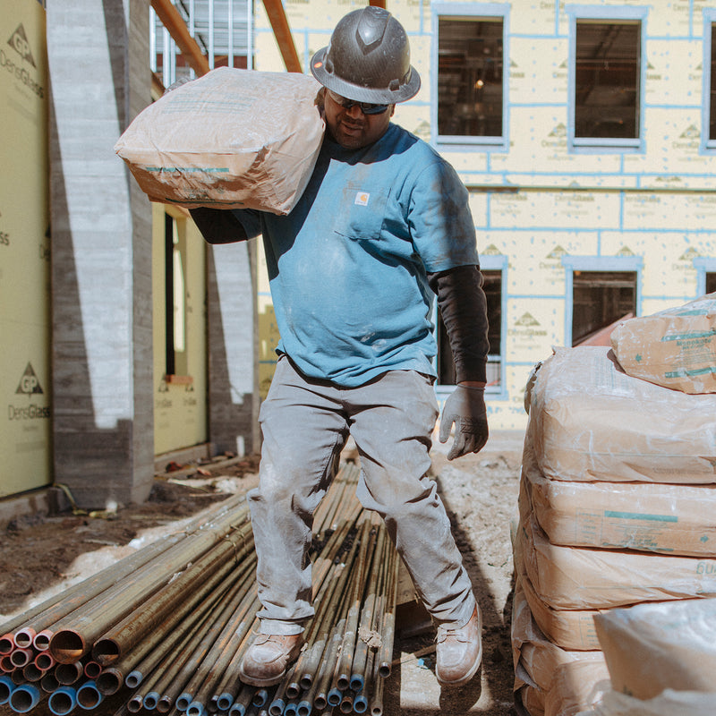 Men's relaxed straight dungaree pants in gravel gray, worn on jobsite with straight legs.