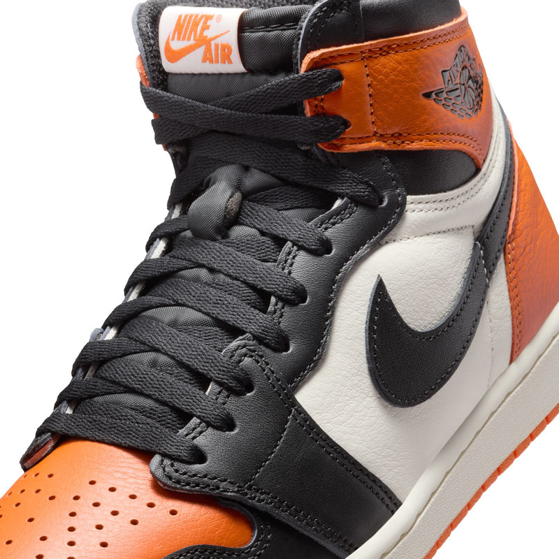Men's high-top sneakers close-up of tongue with NIKE AIR tag and orange collar.