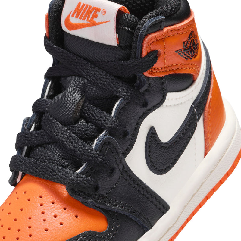 Toddler high-top sneaker close-up with black laces, orange panels, and Nike swoosh