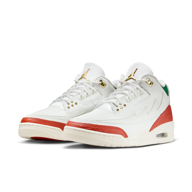 Pair of white retro sneakers with red side panel, green collar, and Air heel