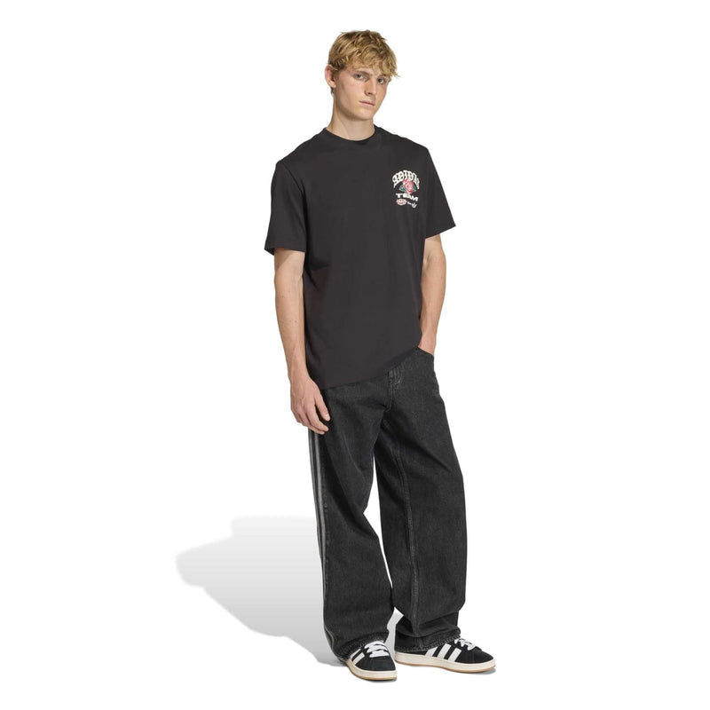 Men's black graphic T-shirt on model with dark jeans and sneakers