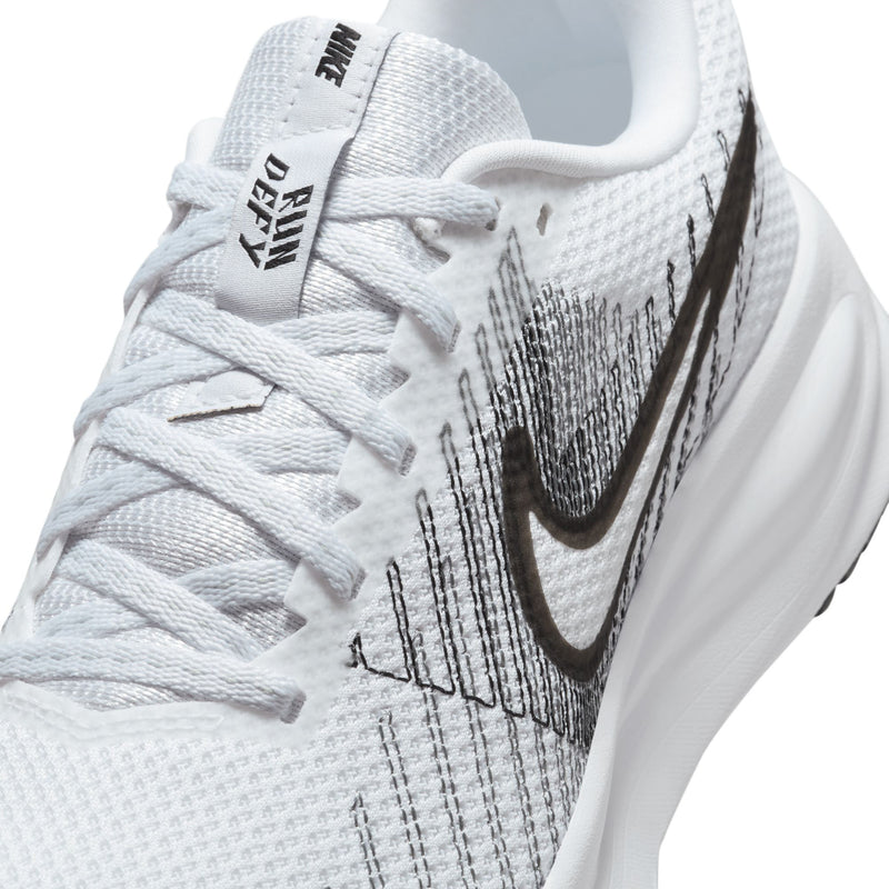 Women's white running shoe upper close-up with lace, knit texture, and black Swoosh