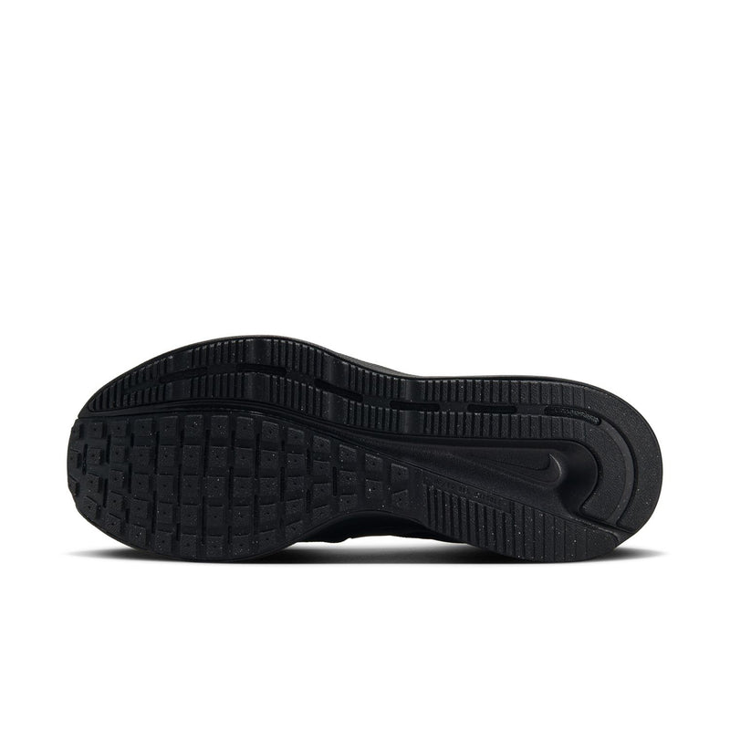Black running shoe outsole with textured tread and curved traction grooves