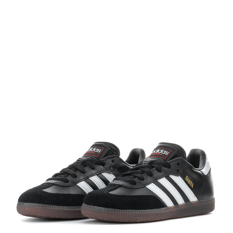 Pair of kids' black Samba Classic sneakers with white stripes and gum-brown sole