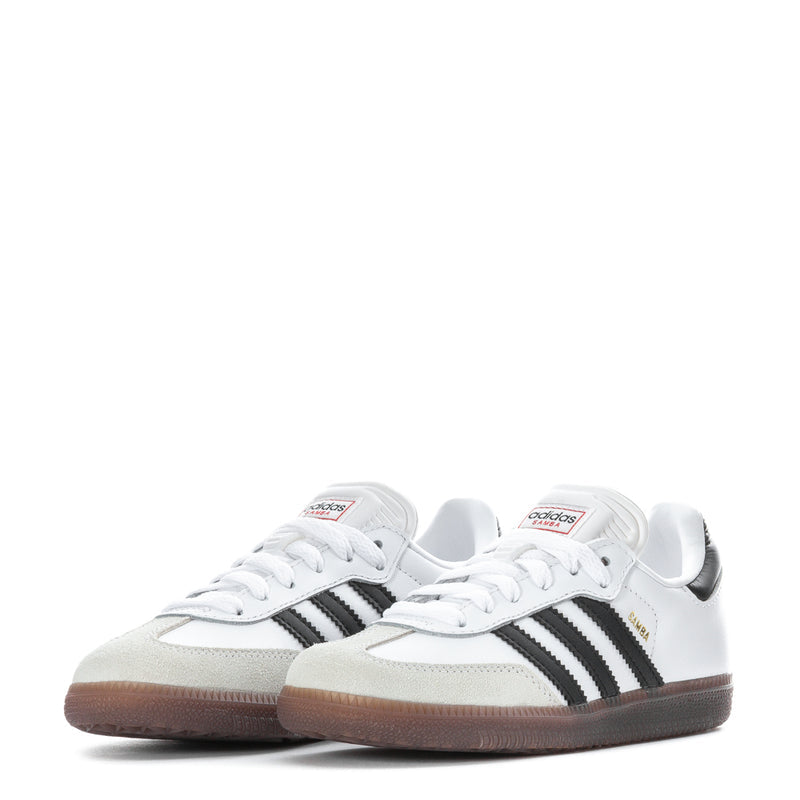 Pair of kids white sneakers with black side stripes and gum-brown rubber sole