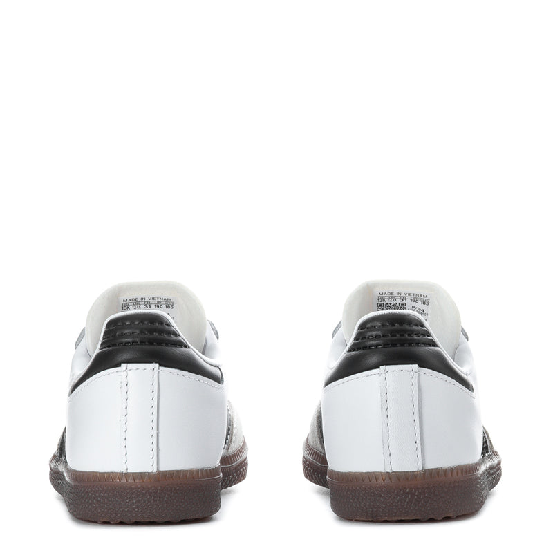 Kids white sneakers from the back with black heel panel and brown rubber sole