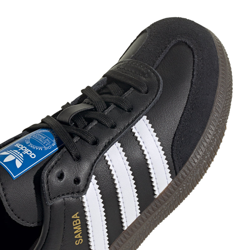 Kids retro sneakers close-up, black laces, white triple stripes, blue tongue tag.