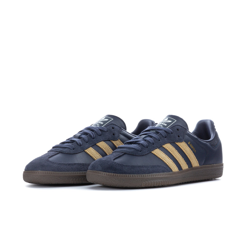 Navy men's low-top Adidas sneakers with gold triple stripes and gum outsole, side view