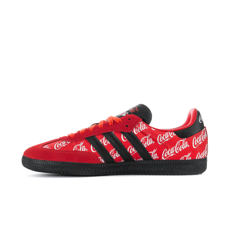 Red and black low-top sneakers with Coca-Cola script, black stripes, and orange laces