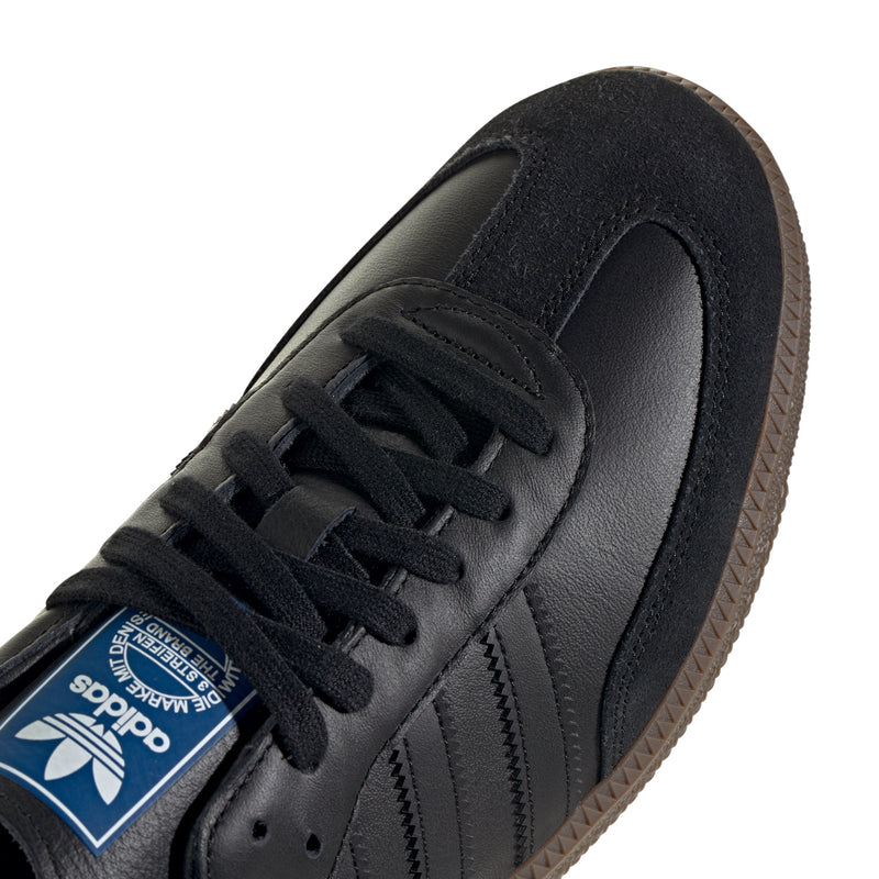 Close-up of black adidas Samba OG sneaker laces, adidas label, and side panel
