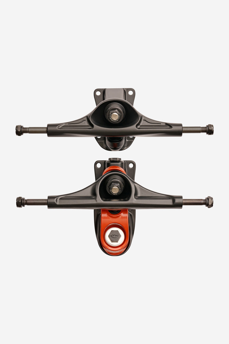 Pair of Slant Surf Skate Trucks 6.25 in black red mounted on a board from above highlighting low ground clearance