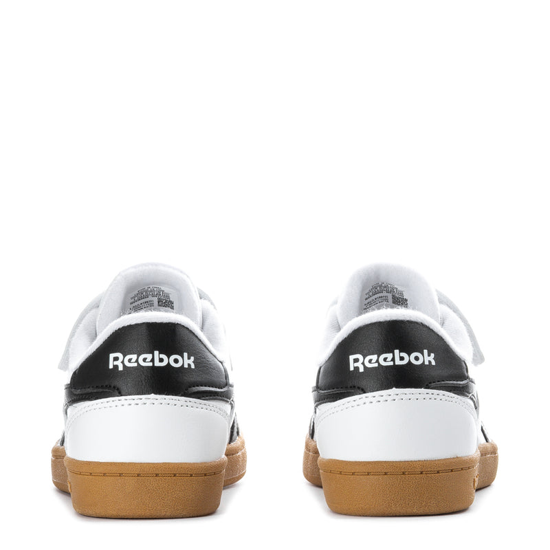 Kids white sneakers with black heel tabs and gum rubber soles