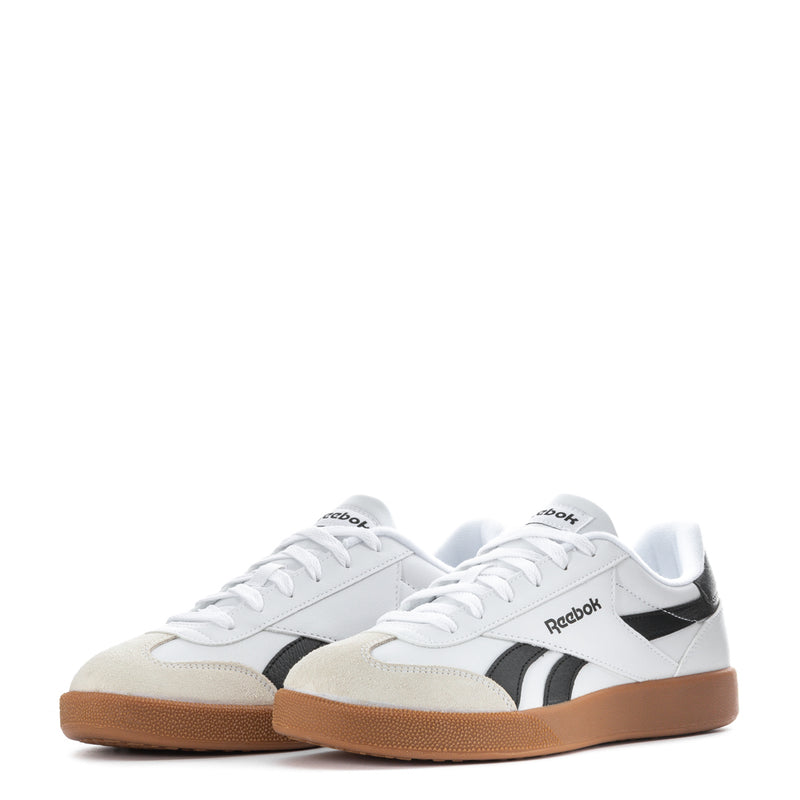 Pair of mens white low-top sneakers with black stripes and gum soles