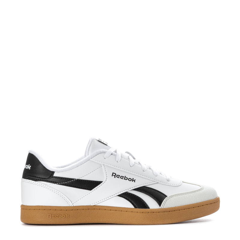 White youth sneakers with black side stripe, Reebok branding, and gum rubber sole