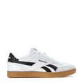 White youth sneakers with black side stripe, Reebok branding, and gum rubber sole