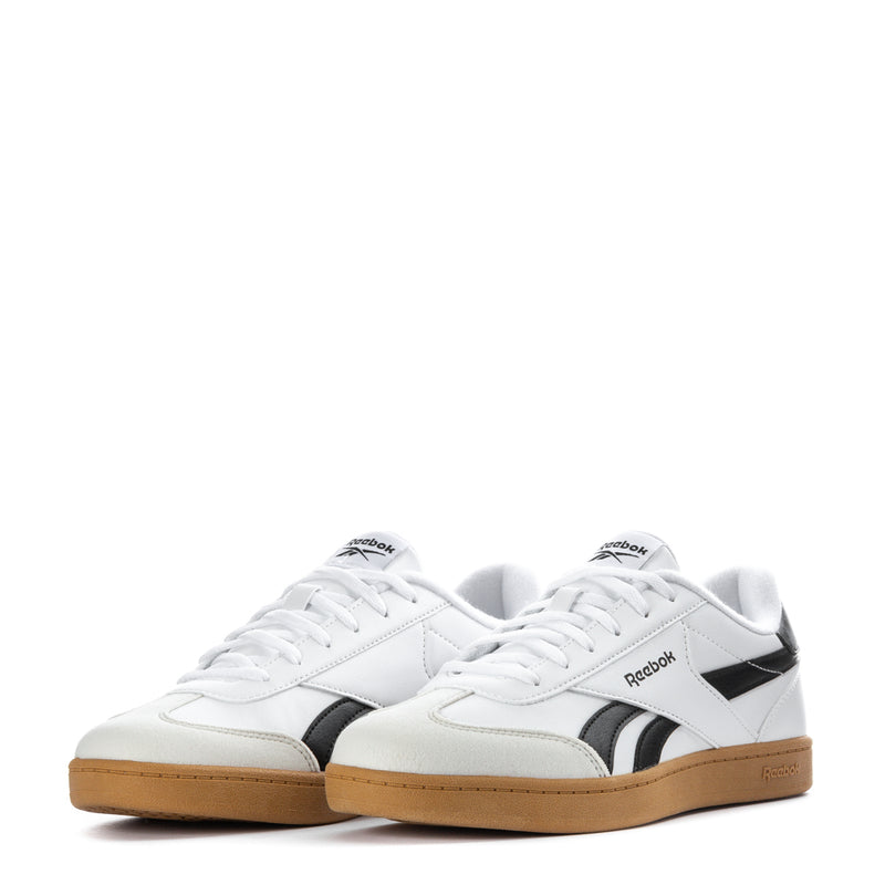 Pair of white youth sneakers with black side stripes and gum soles, lace-up style