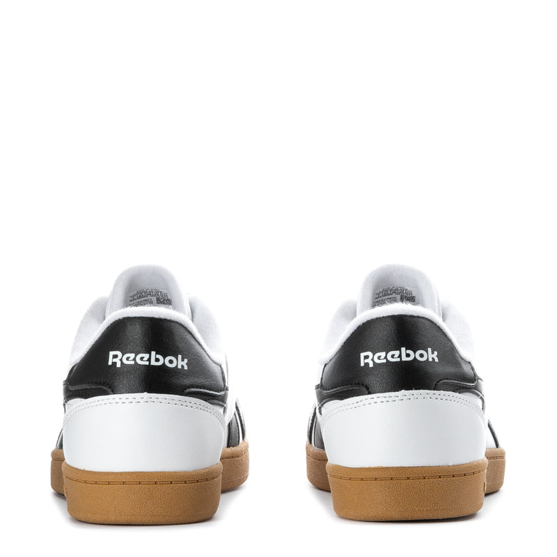 Back view of white youth sneakers with black heel tab, gum sole, and Reebok logo