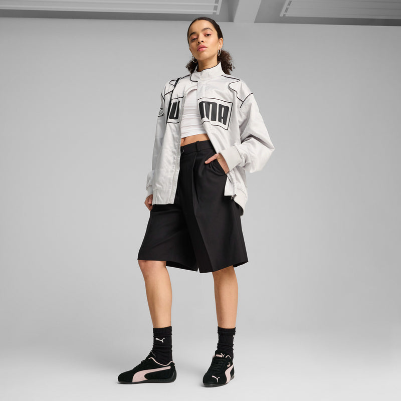 PUMA Speedcat OG sneakers on a model: black upper with mauve trim and lace-up front