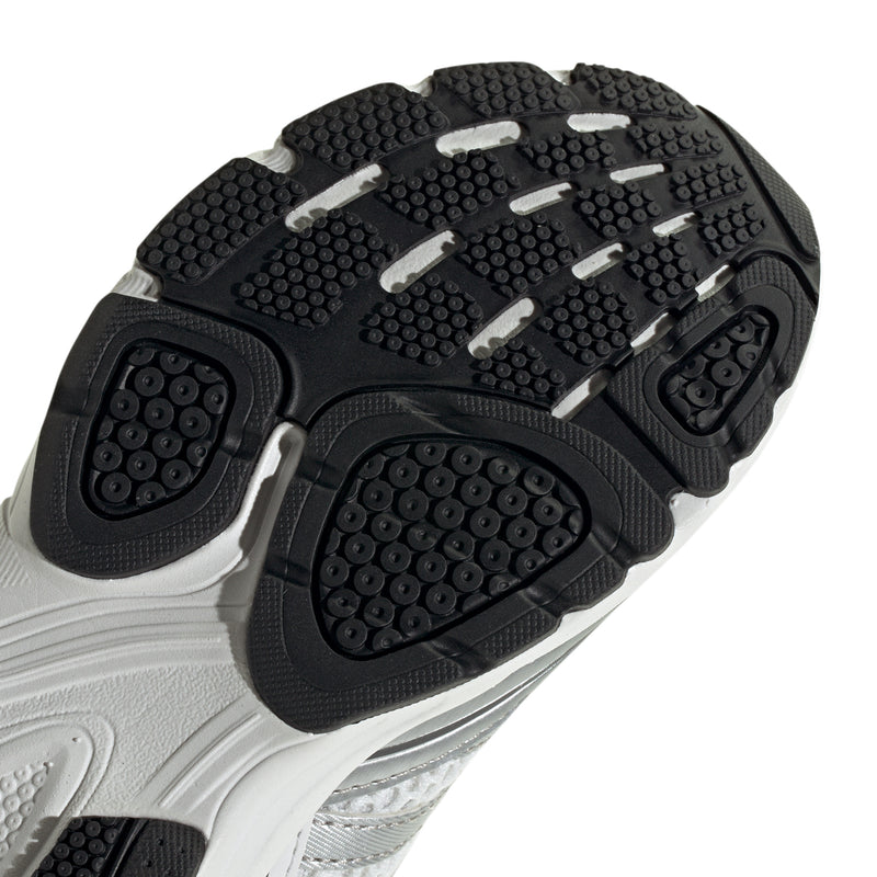 Grey kids sneaker bottom close-up with black traction nubs and circular grip pods
