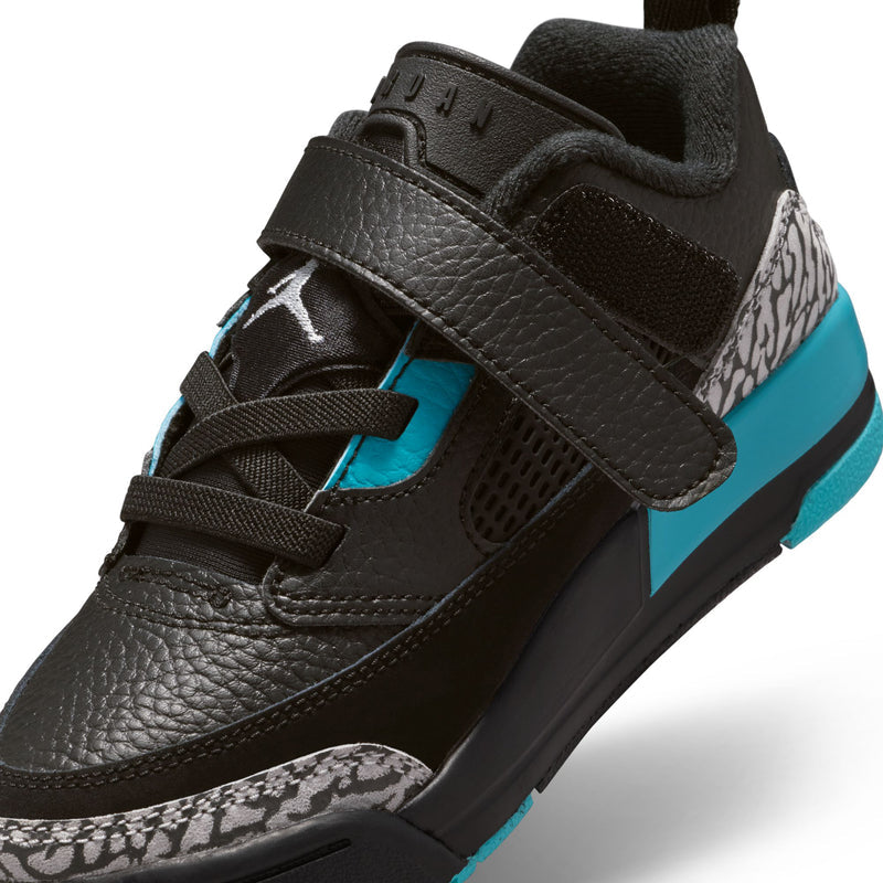 Kids black low-top sneakers close-up with turquoise straps, grey patterned toe, side view