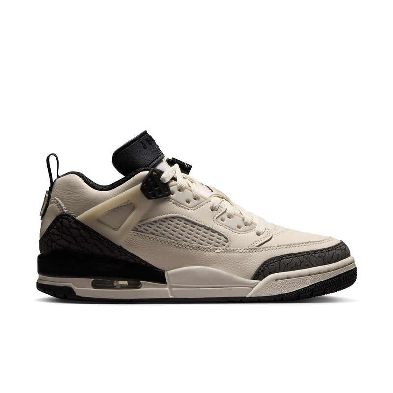 Women’s low-top sneaker in cream with black accents, lace-up, rubber sole.