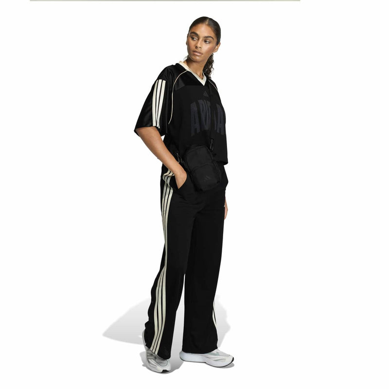 Women's black mesh stadium tee with white side stripes, worn with black pants