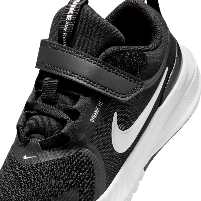 Kids black sneaker close-up with padded collar, stitched strap, and white Swoosh