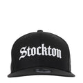 Black baseball cap with white Stockton logo, flat brim and adjustable strap