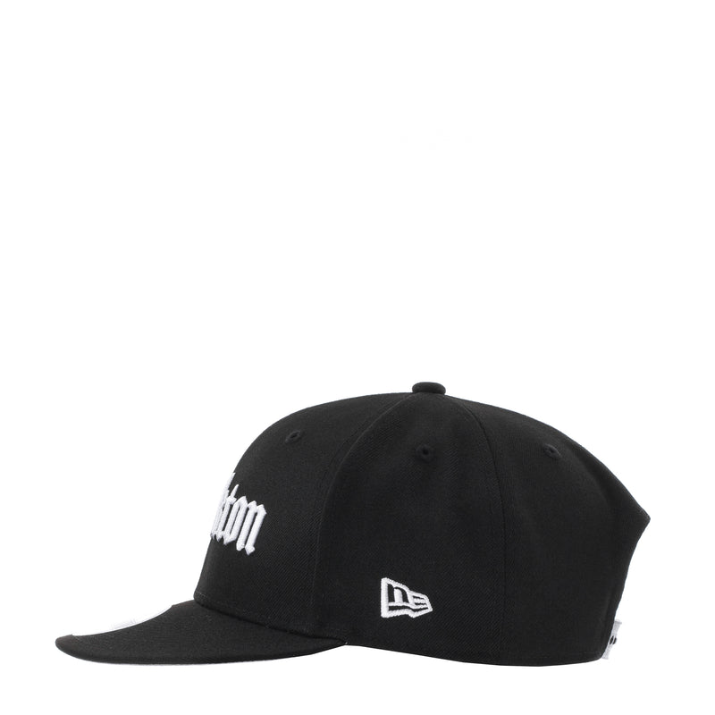 Black baseball cap with partial white Stockton text and New Era flag patch
