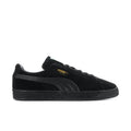 Black suede low-top sneakers with lace-up, Puma logo, and textured rubber sole.