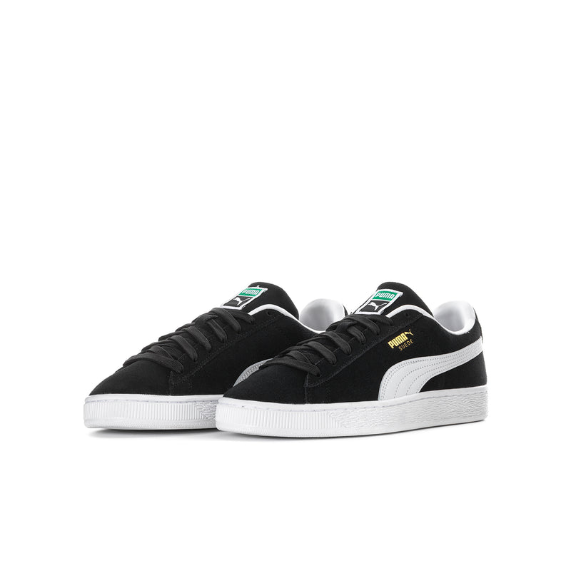 Youth suede sneakers pair, black uppers with white midsoles and Puma stripes