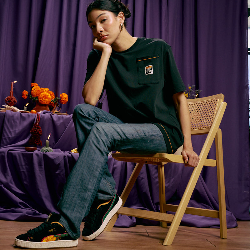 Black suede sneakers with colorful side artwork and rainbow stripe trim, off-white sole.