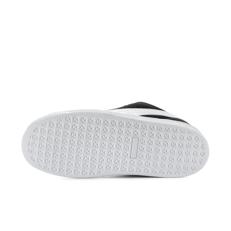 Black suede sneaker outsole view with textured white rubber tread and logo mark