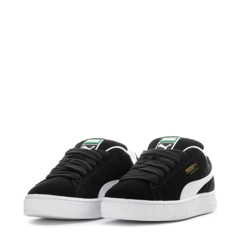 Pair of black suede youth sneakers with white stripe and black lace-up design